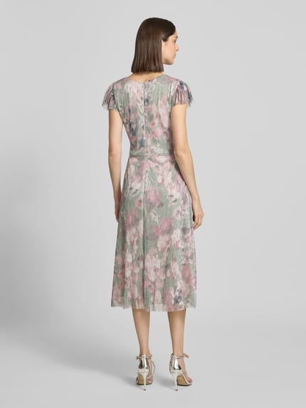 Modelka nosi Schimmerndes Cocktailkleid mit Rundhalsausschnitt von Swing, materiał z domieszką stretchu, krój taliowany, połysk, długość midi, dekolt okrągły, szerokość w rozmiarze 36: 37 cm, długość tyłu 115 cm, długość rękawa 8 cm, pastelowe kolory, kwiatowy wzór, struktura plisowana, widok całej sylwetki z tyłu