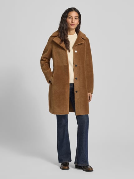 Kobiece modelka nosi płaszcz z funkcją dwustronną, model 'VENUS' od OAKWOOD, krój regular fit, kołnierz z połami, kolor brązowy, długość tyłu 90 cm, szerokość ramion 44 cm, szerokość klatki piersiowej 52 cm, długość rękawów 62 cm, gładka tekstura, pełen widok z przodu.