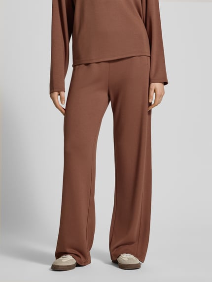 Frauenmodel trägt Regular Fit Sweatpants aus Viskose-Mix von s.Oliver RED LABEL in Braun mit elastischem Bund und seitlichen Taschen, Nahaufnahme Unterkörper.