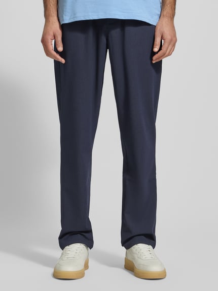 Männermodel trägt dunkelblaue Stoffhose mit elastischem Bund Modell 'Como' von Les Deux, lockerer Schnitt, Nahaufnahme Unterkörper.