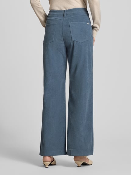Frauenmodel trägt Regular Fit Cordhose mit weitem Bein von S. OLIVER BLACK LABEL, uni-blau, sichtbare Struktur, Gesäßtaschen, Ganzkörperansicht Rückansicht.