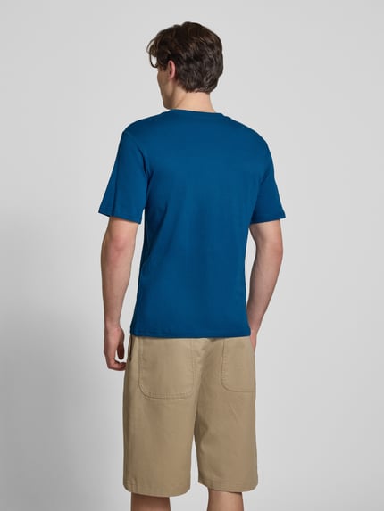 Männermodel trägt T-Shirt mit Logo und Rundhalsausschnitt von Jack & Jones in Blau, Reine Baumwolle, Regular-Fit, Rückenlänge 68 cm, Ganzkörperansicht Rückansicht.