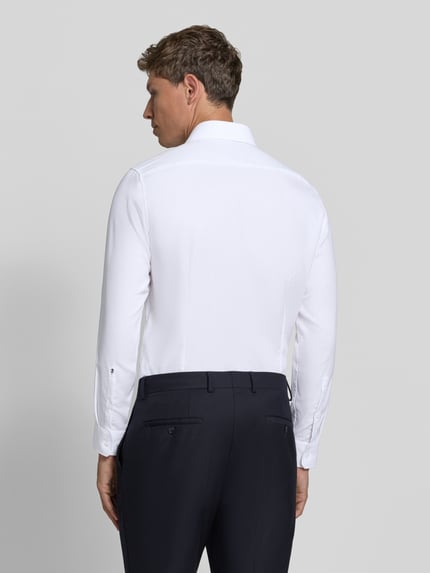 Männermodel trägt Slim Fit Businesshemd mit Kentkragen von Seidensticker, unifarben, langarm, Webware, Ganzkörperansicht Rückansicht.