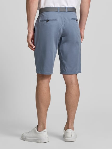 Männermodel trägt Bermudas aus Light Baumwolle mit Gürtel von Christian Berg Men in Blau mit Eingriff- und Gesäßtaschen, Ganzkörperansicht Rückansicht.