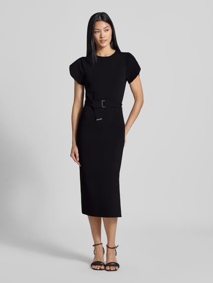 Kobiece modelka nosi czarną sukienkę midi z mieszanki wiskozy o kroju slim fit Model 'JULIANY' od Ted Baker z okrągłym dekoltem i paskiem, długość tyłu 110 cm, szerokość w rozmiarze 36: 37 cm, długość rękawa 14 cm, widok całej sylwetki z przodu.