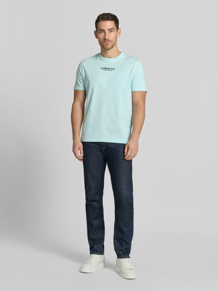 Männermodel trägt Regular Fit T-shirt aus pure katoen van s.Oliver RED LABEL, look: effen kleuren, labelprint, ronde hals, korte mouw, Ganzkörperansicht von vorne.