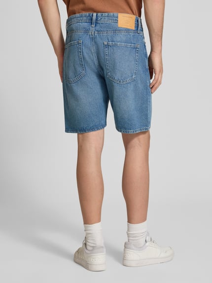 Männermodel trägt korte jeans van puur katoen, loose fit, used-look, steekzakken, model 'TONY' van Jack & Jones, ganzlichaamsbeeld achteraan.