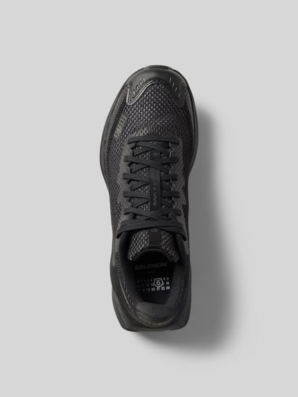 Produktfoto, Sneaker mit Schnürverschluss von MM6 Maison Margiela, zaokrąglony kształt, etykieta, teksturowana podeszwa, czarny kolor