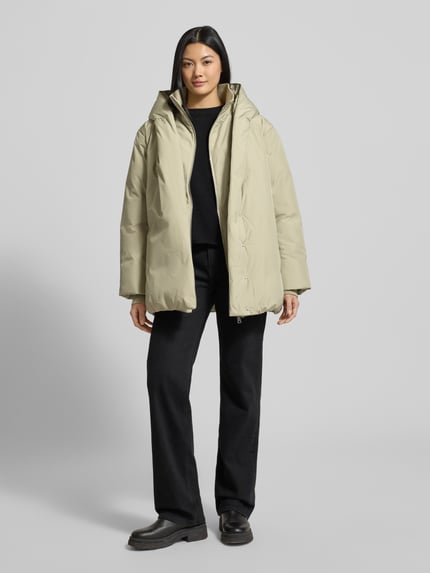 Frauenmodel trägt Regular Fit Outdoor-Jacke mit Stehkragen Modell 'Helah' von Opus in Beige mit Kapuze, elastischen Ärmelabschlüssen, Vorderansicht Ganzkörperansicht. Rückenlänge 74 cm, Schulterbreite 53 cm, Brustweite 54 cm, Ärmellänge 63 cm bei Größe 36.