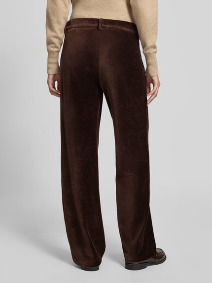 Frauenmodel trägt Regular Fit Cordhose mit Bundfalten Modell 'MAINE' von BRAX in unifarbener, brauner Cordstruktur mit Bundfalte und Gesäßtaschen, Ganzkörperansicht Rückansicht.