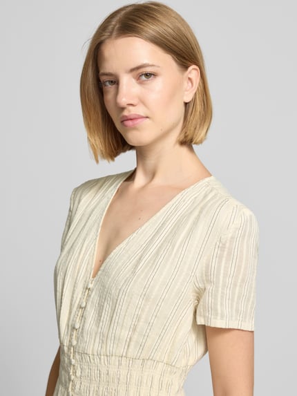 Vrouwenmodel draagt Midikleid met V-hals en knoopsluiting van Jake*s in katoenmix, getailleerd model, lichte kleur, streeptekening, Nahaufnahme Oberkörper.