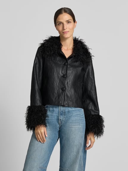 Frauenmodel trägt schwarze Jacke in Leder-Optik Modell 'Tracy' von LOLLYS LAUNDRY mit Kunstfell, große Knöpfe, Ganzkörperansicht von vorne. Rückenlänge 51 cm, Schulterbreite 40 cm, Brustweite 51 cm, Ärmellänge 61 cm, Regular Fit.