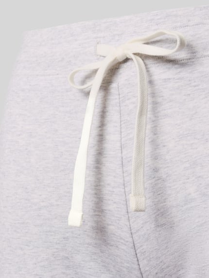 Vrouwenmodel draagt Pyjama-Hose met elastisch Bund van Skiny, mix van katoen en elastaan, slim fit, tunnelkoord, labeldetail. Detailopname.