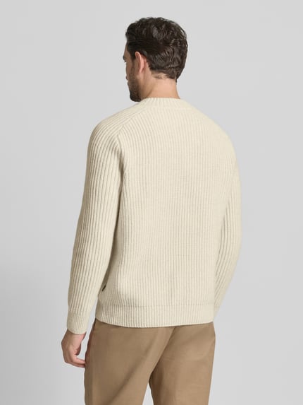 Männermodel trägt Shaped Fit Strickpullover aus Schurwoll-Mix Modell 'KARINET' von BOSS Orange, Optik: Unifarben, Zopfmuster, Ganzkörperansicht Rückansicht