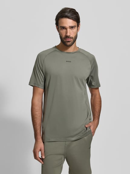 Mannelijk model draagt Regular Fit T-shirt met Flatlock-naden Model 'TEE ACTIVE 1' van BOSS Green, look: effen, lichte stretchstof, labelprint op de borst, ronde hals, korte raglanmouwen, sneldrogend. Ganzkörperansicht van voren.