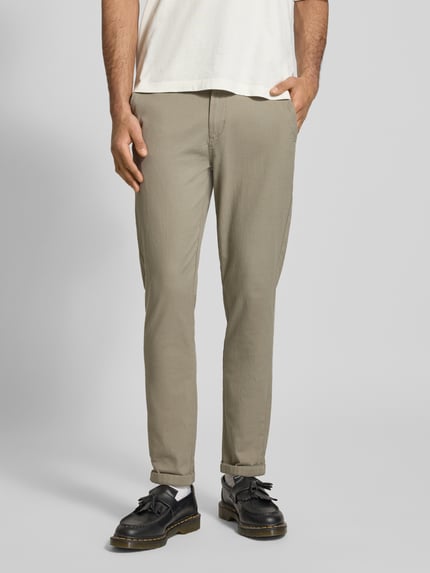 Mężczyzna nosi Straight Fit Stoffhose aus Baumwoll-Mix Modell 'MARCO FURY' od Jack & Jones, beżowy kolor, matowa tekstura, Szerokość w rozmiarze 32/32: 44 cm, długość nogawki wewnętrznej: 77 cm, całkowity widok z przodu, kontekst: spodnie materiałowe z bawełny z dodatkiem elastanu, kieszenie wpuszczane i tylne, zapięcie na guzik i zamek.
