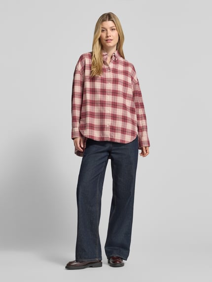 Frauenmodel trägt Langarmbluse mit Button-Down-Kragen von BOSS Orange, mehrfarbig kariert, Webware, Ganzkörperansicht von vorne.