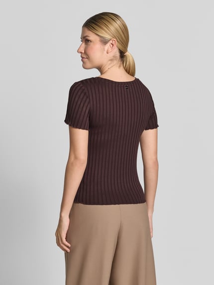 Frauenmodel trägt Slim Fit T-Shirt aus Viskose-Mix von Rich & Royal in Dunkelbraun mit Kräuselsäumen und Rundhalsausschnitt, Ganzkörperansicht Rückansicht.