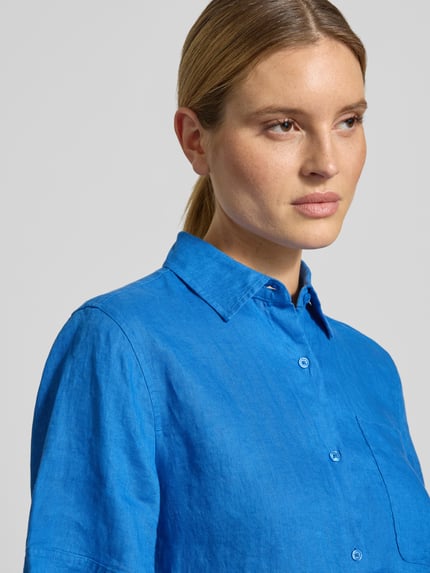 Frauenmodel trägt Loose Fit Leinenbluse mit Brusttasche von Tommy Hilfiger, Optik: Unifarben, Hemdblusenkragen, Logo-Stitching, Material: Leinen, Nahaufnahme Oberkörper.