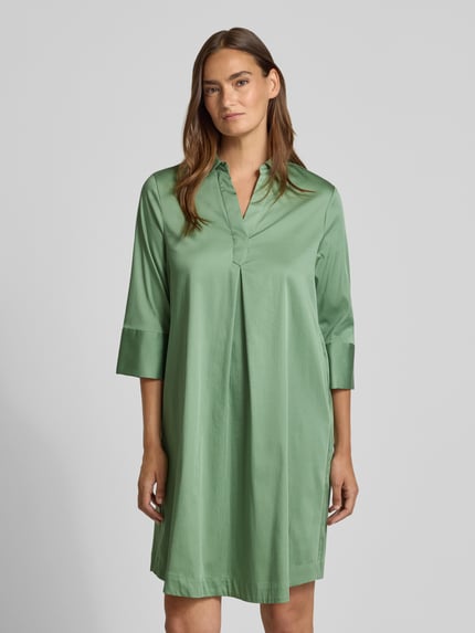 Frauenmodel trägt A-Linie Freizeitkleid aus Baumwoll-Mix von s.Oliver BLACK LABEL in sanftem Grün, glatte Struktur, Ganzkörperansicht von vorne.
