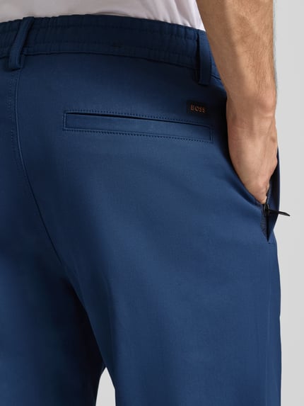 Männermodel trägt Tapered Chino mit Kordelzug Modell 'CHINO ST-P' von BOSS Orange, Unifarben, Baumwoll-Mix, Detailaufnahme Rückansicht.