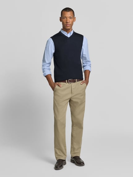Männermodel trägt Slim Fit Pullunder aus Baumwoll-Mix mit V-Ausschnitt von Christian Berg Men, Strick-Optik, Ganzkörperansicht von vorne.