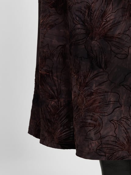 Frauenmodel trägt Midirock im Allover-Look Modell 'SESSOLANA' von FREE/QUENT, gerade Form, dunkle Töne, Strukturmuster, Nahaufnahme Oberkörper. Material-Mix mit Stretch-Anteil.