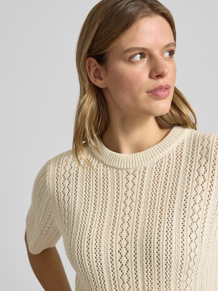 Frauenmodel trägt Regular Fit Strickshirt aus reiner Baumwolle Modell 'NUKA' von Pieces, Optik:Allover-Muster, Lochstrick, Gestreift, Rundhals, Kurzarm, Nahaufnahme Oberkörper.