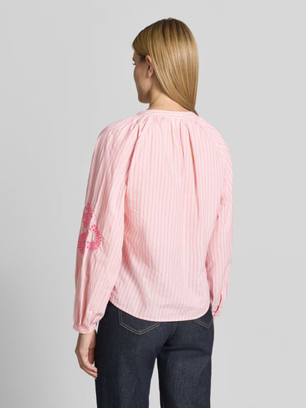 Frauenmodel trägt Regular Fit Bluse mit floralem Stitching von Emily Van den Bergh in Rosa mit Streifen, Reine Baumwolle, Langärmelig, Tunika-Ausschnitt, Eingefasste Ärmelabschlüsse, Rückenlänge 58 cm, Ärmellänge 47 cm, Ganzkörperansicht Rückansicht.