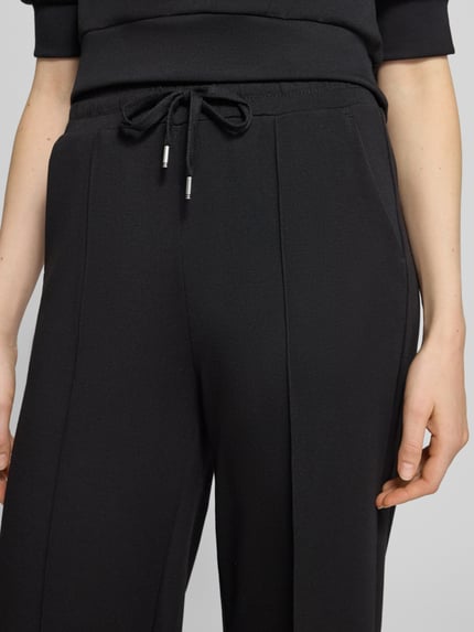 Frauenmodel trägt Regular Fit Hose mit High Waist Jersey von Soyaconcept, unifarben, Struktur, Wide Leg, Tunnelzug, seitliche Eingrifftaschen, Nahaufnahme Oberkörper.