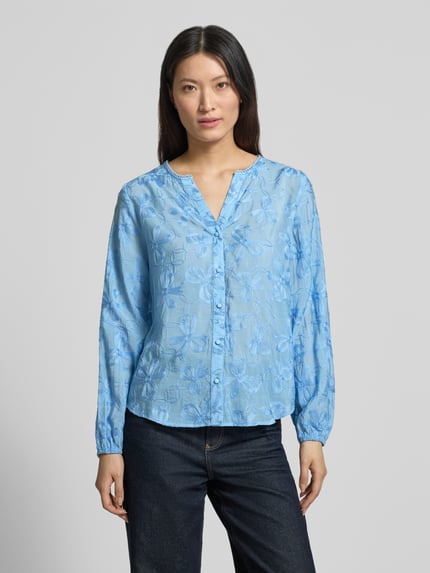 Vrouwenmodel draagt Bluse aus Viskose-Mix mit Knopfleiste Modell 'Randy' van FREE/QUENT in lichtblauw met bloemenstructuur, straight fit, Serafino-kraag en elastische mouwuiteinden, damesblouse, voorkant volledig in beeld, ganzekörperansicht van voren.