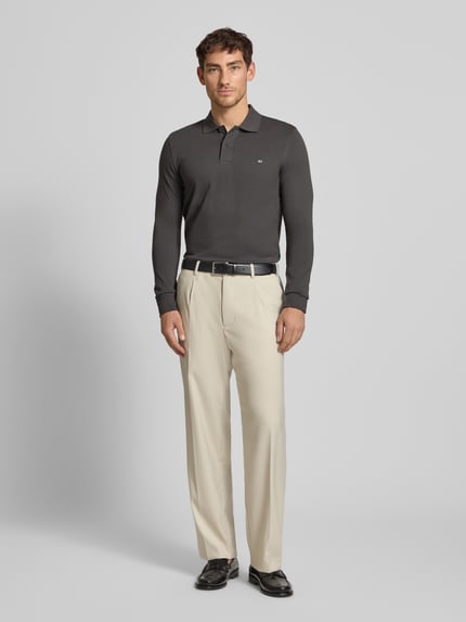 Männermodel draagt Poloshirt met Label-Stitching Modell 'PAXTON' van Christian Berg Men, slanke pasvorm, effen grijs, voorkant volledige lichaamsweergave.