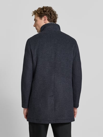 Männermodel trägt Regular Fit Mantel mit Stehkragen van Christian Berg Men, kleur donkergrijs, wolmix, knoopsluiting, patzakken, ruglengte 89 cm, schouderbreedte 49 cm, borstwijdte 50 cm, mouwlengte 66 cm, geheelopname achterkant.