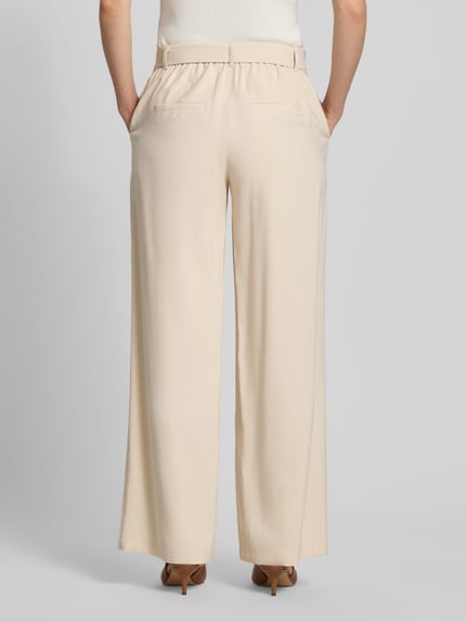 Vrouwenmodel draagt Loose Fit Weite Hose aus Viskose-Mix van s.Oliver BLACK LABEL in effen kleuren, viscosemix, high waist, regular lengte, steekzakken, riemlussen, boord, sluiting met haak en ritssluiting, opgestikte steekzakken, elastisch boord, textielriem, schijnachterzakken. Volledig aanzicht achterkant.