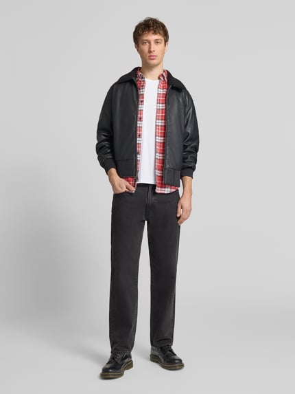 Männermodel trägt T-Shirt aus Baumwolle von Alpha Industries, Herren T-Shirt in Reine Baumwolle, Gerader-Schnitt, Rundhalsausschnitt, Label-Details, Rückenlänge 68 cm bei Größe M, Ganzkörperansicht von vorne.