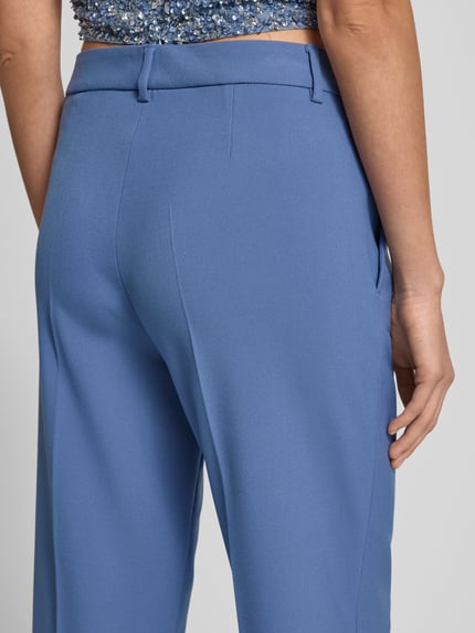Frauenmodel trägt Wide Fit Stoffhose mit Viskose-Anteil Modell 'Olessa' von Raffaello Rossi in Hellblau, glatte Textur, Detailaufnahme Rückansicht. Elastischer Material-Mix, Bügelfalten, Haken- und Reißverschluss, Bundweite 41 cm, Innenbeinlänge 66 cm bei Größe 36.