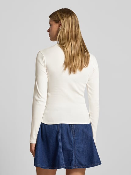 Frauenmodel trägt Longsleeve mit Rundhalsausschnitt Modell 'EVERYDAY' von TOPSHOP aus reiner Baumwolle in Creme und Jeansrock, Ganzkörperansicht Rückansicht.