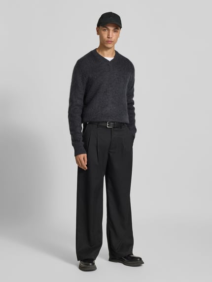 Männermodel trägt Regular Fit Pullover mit V-Ausschnitt von ANNARR in dunkler Strick-Optik, gerippte Abschlüsse, Ganzkörperansicht von vorne.