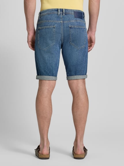 Mężczyznę model nosi Regular Fit Jeans Bermudas aus Baumwoll-Mix von Tom Tailor, denim, krój regular fit, z przodu, widok całej sylwetki.