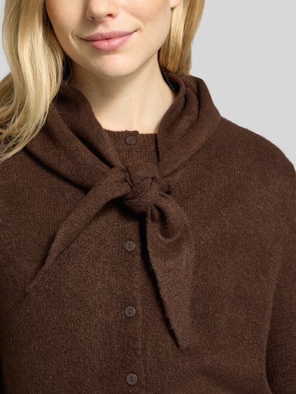 Frauenmodel trägt Cardigan Modell 'SEEDSUN' mit Schaloptik von MANGO, unifarben braun, Strickstruktur, Knopfleiste, Nahaufnahme Oberkörper.