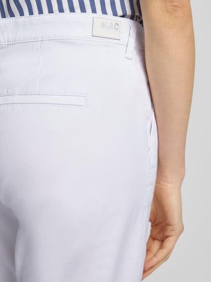 Frauenmodel trägt Chino mit Eingrifftaschen von MAC in Weiß, Baumwoll-Elasthan-Mix, Regular Fit, Gesäßtaschen, Nahaufnahme Rückansicht.