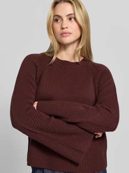 Frauenmodel trägt Pullover mit ausgestelltem Ärmel Modell 'Maple' von Joseph in unifarbener Strickoptik, Regular Fit, Rundhals, Feinstrick, Ganzkörperansicht von vorne.