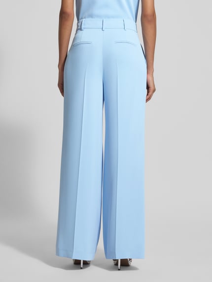 Vrouwenmodel draagt Wide Fit stoffen broek met persplooien van Christian Berg Cocktail, lichtblauw met achterzakken, haakjes- en ritssluiting, bandwijdte maat 36: 33 cm, binnenbeenlengte maat 36: 80 cm, wide fit, volledig zicht van achteren.
