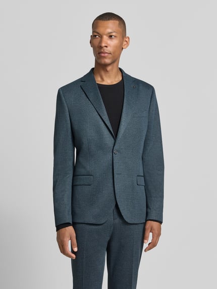 Männermodel trägt Slim Fit Sakko mit Lyocell-Anteil Modell 'Nick' von Zuitable in Blau mit Reverskragen und Pattentaschen, Ganzkörperansicht von vorne. Material-Mix, integriertes Einstecktuch, Knopfleiste, Brusttasche.