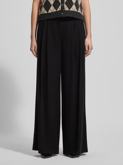 Frauenmodel trägt Hose aus Viskose-Mix mit weitem Bein von MAC, Schwarz, Gelegte Falten, Gesäßtaschen, Nahaufnahme Vorderansicht.