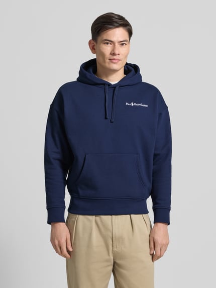 Männermodel trägt Relaxed Fit Hoodie mit Label-Stitching und Känguru-Tasche von Polo Ralph Lauren, Baumwoll-Mix, Ganzkörperansicht von vorne. Herren Hoodie, dunkelblau.
