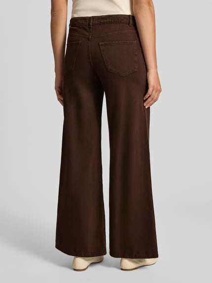 Frauenmodel trägt Wide Fit Jeans mit Eingrifftaschen von REVIEW, reine Baumwolle, braun, locker geschnitten, Ganzkörperansicht Rückansicht.