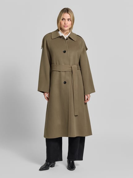 Frauenmodel trägt Mantel mit Bindegürtel Modell 'AQUALUNG' von IRO in Olive, unifarben, strukturierte Webware, Oversized Fit, Teilungsnähte, Ganzkörperansicht von vorne.