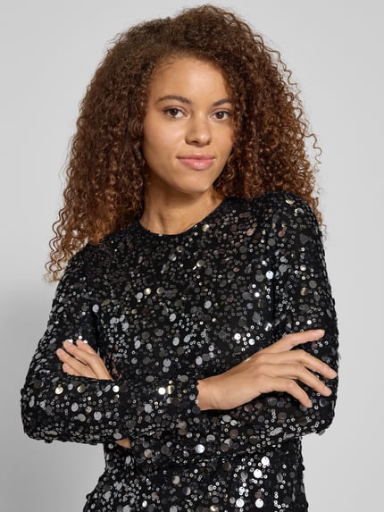 Frauenmodel trägt fließendes Abendkleid mit Paillettenbesatz Modell 'ANIKA CATINA' von Only in glänzendem Schwarz, Nahaufnahme Oberkörper.
