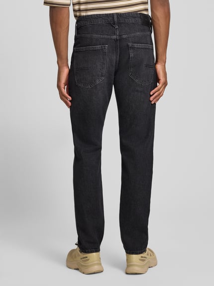 Männermodel trägt Straight Fit Jeans aus Baumwoll-Mix von s.Oliver RED LABEL in dunklem Grau, strukturierte Oberfläche, Ganzkörperansicht Rückansicht.